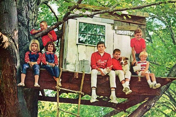 A photograph of Phillip (center) and friends in a treehouse, c. 1995.